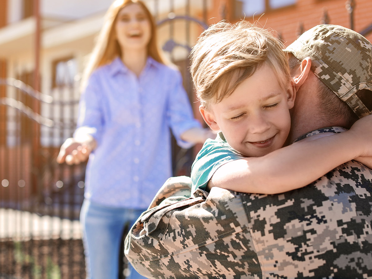 hugging a veteran in uniform.