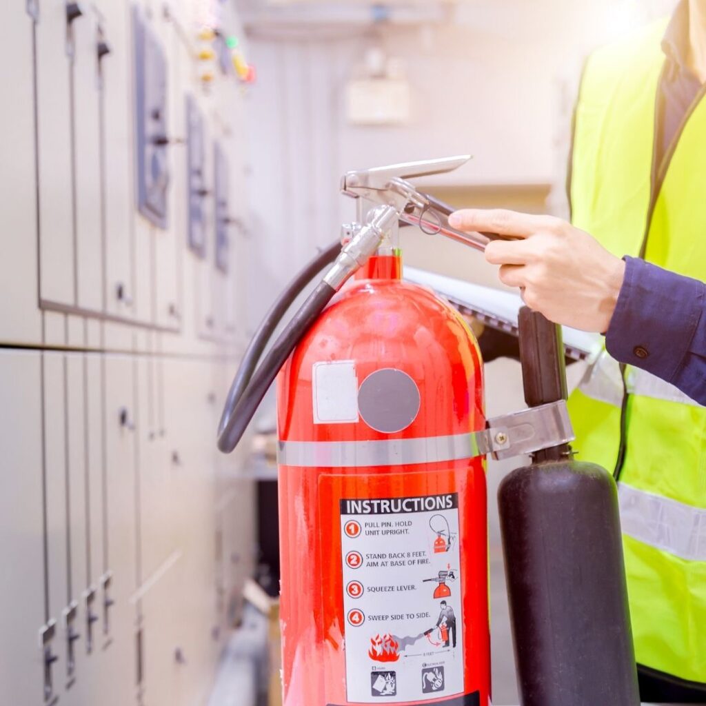 man inspecting a fire extinguisher