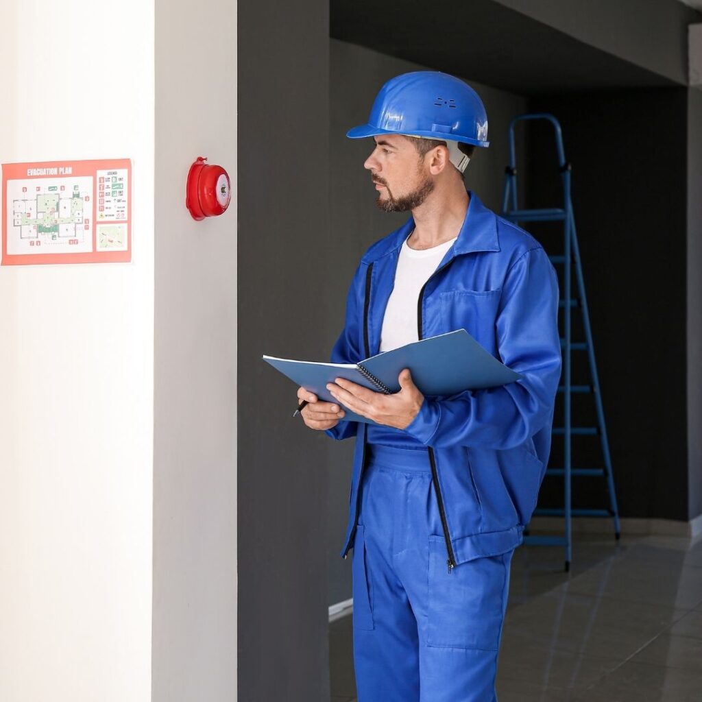 man inspecting a fire alarm