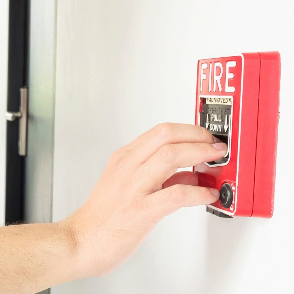 man inspecting a fire alarm