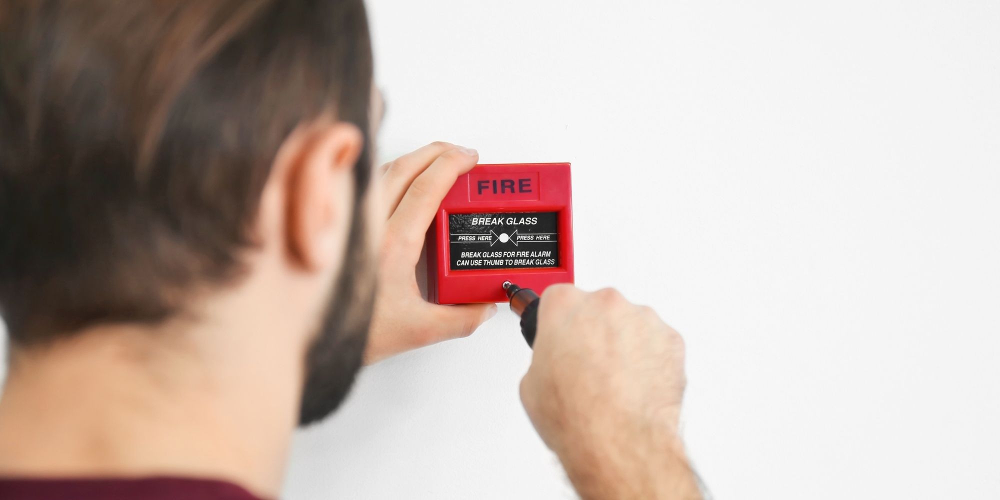 man inspecting a fire alarm